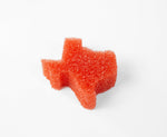 Three-quarter view of an orange Texas-shaped Scrub Daddy sponge showing textured foam on a white background