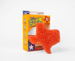 Scrub Daddy Texas-shaped orange sponge displayed leaning against its yellow retail packaging on white background