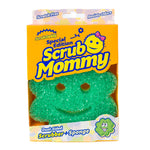 Green flower-shaped Scrub Mommy scrubber-sponge visible in orange branded Scrub Mommy retail box with smiling logo