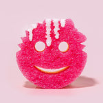 Pink Scrub Mommy scrubber sponge standing upright with white liquid drips on a pink background