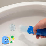 Hand holding a blue dispenser applying a pale gel stamp inside a white toilet bowl, small Scrubbing Bubbles mascot graphic at corner.