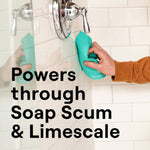 Hand using a turquoise scrub sponge on white tiled shower with overlaid text 'Powers through Soap Scum & Limescale'