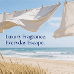 Linen sheets hanging on a clothesline over a beach scene with text luxury fragrance everyday escape evoking sea salt linens