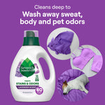 Seventh Generation lavender detergent bottle with circular insets showing purple clothing and a sleeping dog, on a purple background