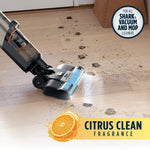 Shark HydroVac cleaning muddy paw prints from hardwood floor with citrus clean fragrance graphic.