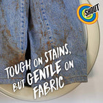 Close-up of heavily stained denim inside a washer with text “Tough on stains, but gentle on fabric” and Shout logo