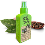 Shübug Active green spray bottle displayed with botanical leaves and peppercorns as natural ingredient props.