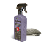Purple Shubug bed bug killer spray bottle with black trigger placed beside folded bedding on a white background