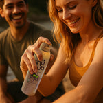 Person spraying a can of Shūbug natural mosquito repellent on their arm in an outdoor, warm-toned scene.