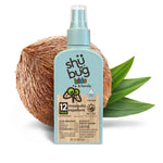 Shübug kids & family blue spray bottle staged in front of a halved coconut and green leaves on white background