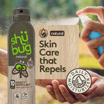 Shübug natural spray can alongside a hand spraying a blue bottle and wood-textured panel reading 'Skin Care that Repels'.
