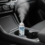 Simoniz Odor Eliminator aerosol can dispensing a visible mist inside a car center console cup holder