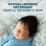 Close-up of a sleeping swaddled baby on a fluffy surface with text stating hypoallergenic detergent gentle on baby's skin.