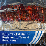 Sliced glazed ribs placed on extra-thick aluminum foil with a meat fork visible at the left edge