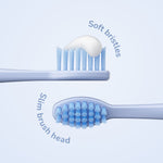 Two close-up views of a slim blue toothbrush head showing soft bristles and a dollop of toothpaste on one side.