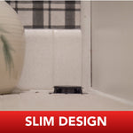 Low-angle shot of a slim black ant bait station installed on a bathroom ledge with tiled background and caption