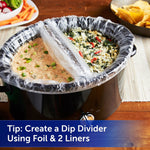 Slow cooker with a clear liner being used as a divided dip server, two different dips visible separated by foil divider
