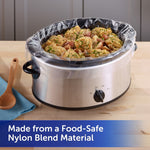 Stainless slow cooker lined with a clear plastic liner filled with cooked chicken and potatoes on a kitchen counter