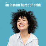 Woman with curly hair smiling against a turquoise background with headline text 'an instant burst of ahhh'.