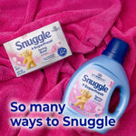 Snuggle SuperFresh bottle and a box of Snuggle dryer sheets placed on a bright pink plush blanket with marketing text.