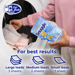 Hands holding a Snuggle Blue Sparkle box over an open dryer with usage guidance icons for sheets per load