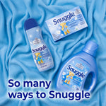 Top-down layout of Snuggle Blue Sparkle bottle, spray and dryer sheet box on blue fabric with 'So many ways to Snuggle' text