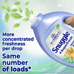 Close-up of a tilted Snuggle SuperFresh bottle pouring scent with floating green leaves and text about concentrated freshness