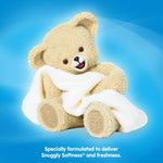 Snuggle teddy bear mascot holding a soft white towel on a bright blue background, promoting freshness and softness.