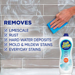Hand scrubbing tiled wall with blue sponge and white cleaner foam, Soft Scrub OXI bottle pictured in lower corner with checklist of removed stains