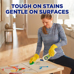 Person cleaning a table with a sponge while holding a Soft Scrub bottle, headline reads tough on stains gentle on surfaces