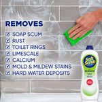 Close-up of tiled surface being scrubbed with a green sponge and a Soft Scrub bleach bottle shown at lower right