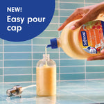 Hand pouring Softsoap milk & honey refill into a pump bottle using new easy pour cap in tiled setting