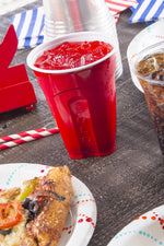 Red Solo squared cup filled with a red beverage on a tabletop with party plates