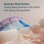 Macro image of Philips Sonicare brush head cleaning along gumline with text 'Sonicare Fluid Action cleans deep between the teeth'