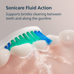 Close-up infographic of a toothbrush head cleaning teeth with fluid action bubbles illustrating bristles reaching between teeth and along gumline.
