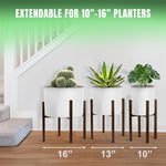 Three brown adjustable plant stands of different widths holding white planters in a staged interior with text reading extendable for 10"-16" planters.