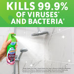 Hand spraying Scrubbing Bubbles aerosol onto tiled shower wall with large text claiming it kills 99.9% of viruses and bacteria.