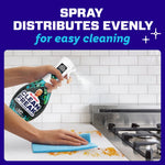 Person spraying Mr. Clean Clean Freak across a countertop while wiping a spill, demonstrating even spray distribution.