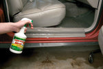 Person spraying Spray Nine along the door sill of a vehicle with visible seat and floor mat inside