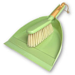 Light green plastic dustpan with a matching hand brush featuring light bristles and a bamboo-style handle with a hanging loop.