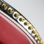 Close-up of multiple small brass spray nozzles mounted along a curved chrome spray bar on a sprinkler