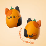 Two views of the exclusive orange pumpkin Squish Cap accessory with cat-like face and green stem shown on a pale background
