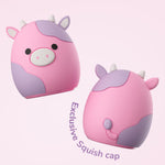 Two views of the pink cow-themed Squishmallows squish cap accessory shown front and back on a pale pink background.