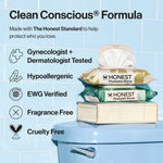 Stacked Honest Flushable Wipes packages on a toilet tank with badge icons and product claims on blue tile background