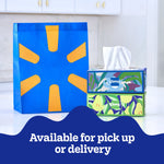 Two decorative Kleenex tissue boxes stacked beside a blue and yellow shopping bag with 'Available for pick up or delivery' banner