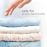 Stack of folded knit and denim garments with a hand hovering above and text stating safe for all colors and fabrics