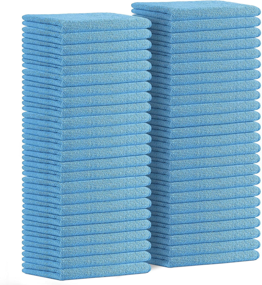 Two tall stacks of folded light blue microfiber cleaning cloths photographed on white background.