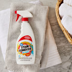 Great Value stain remover spray bottle lying on folded towels next to a wicker basket and marble surface