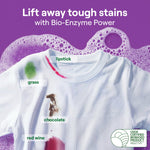 White T-shirt showing labeled stains like grass, lipstick, chocolate and red wine against a purple soapy background promoting stain removal