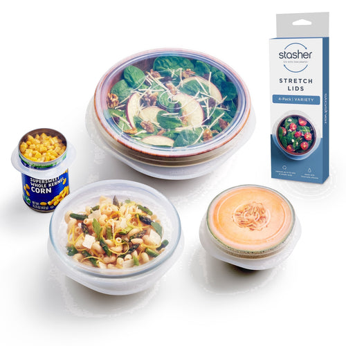 Clear reusable silicone stretch lids covering bowls and a halved melon, arranged with packaged box at right